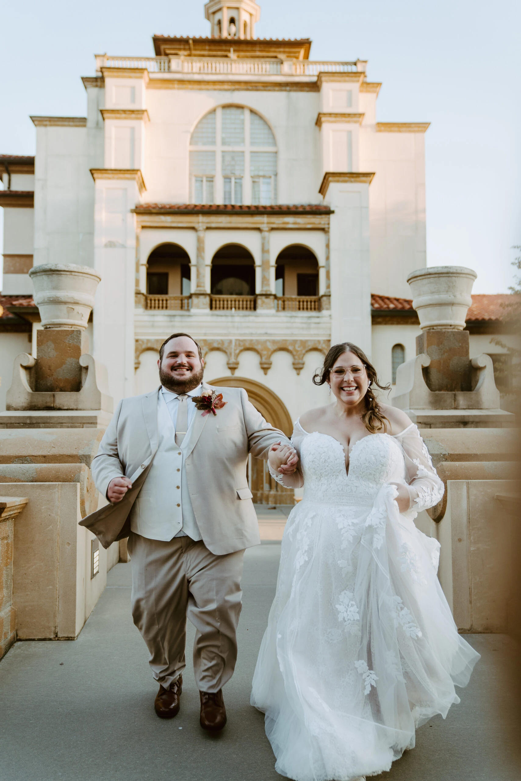 true bride Rachel and husband Thomas running downstairs holding handing after ceremony