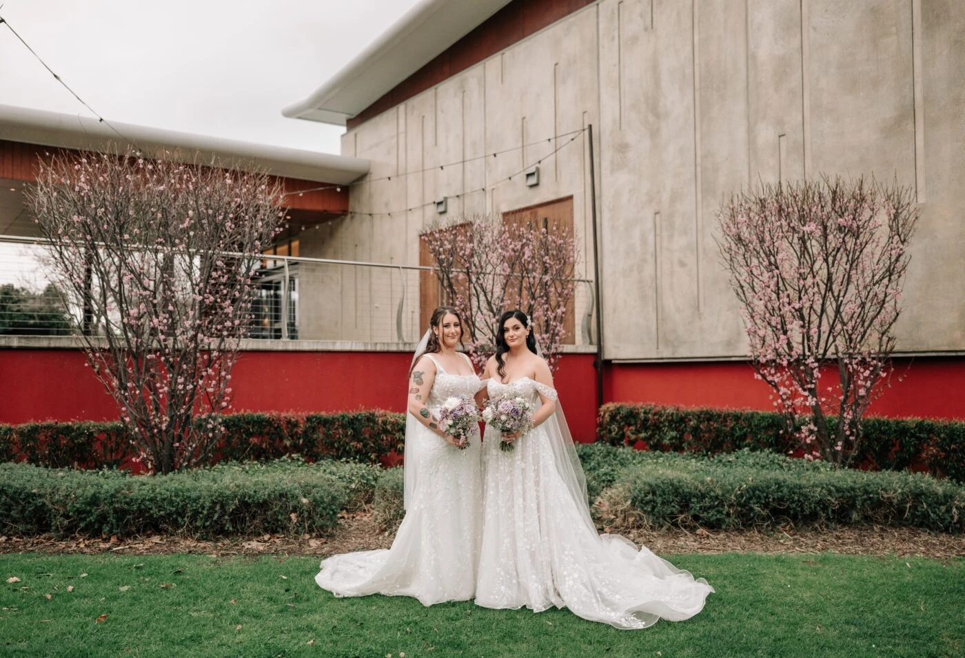 Brides wearing lace wedding dresses standing at the alter