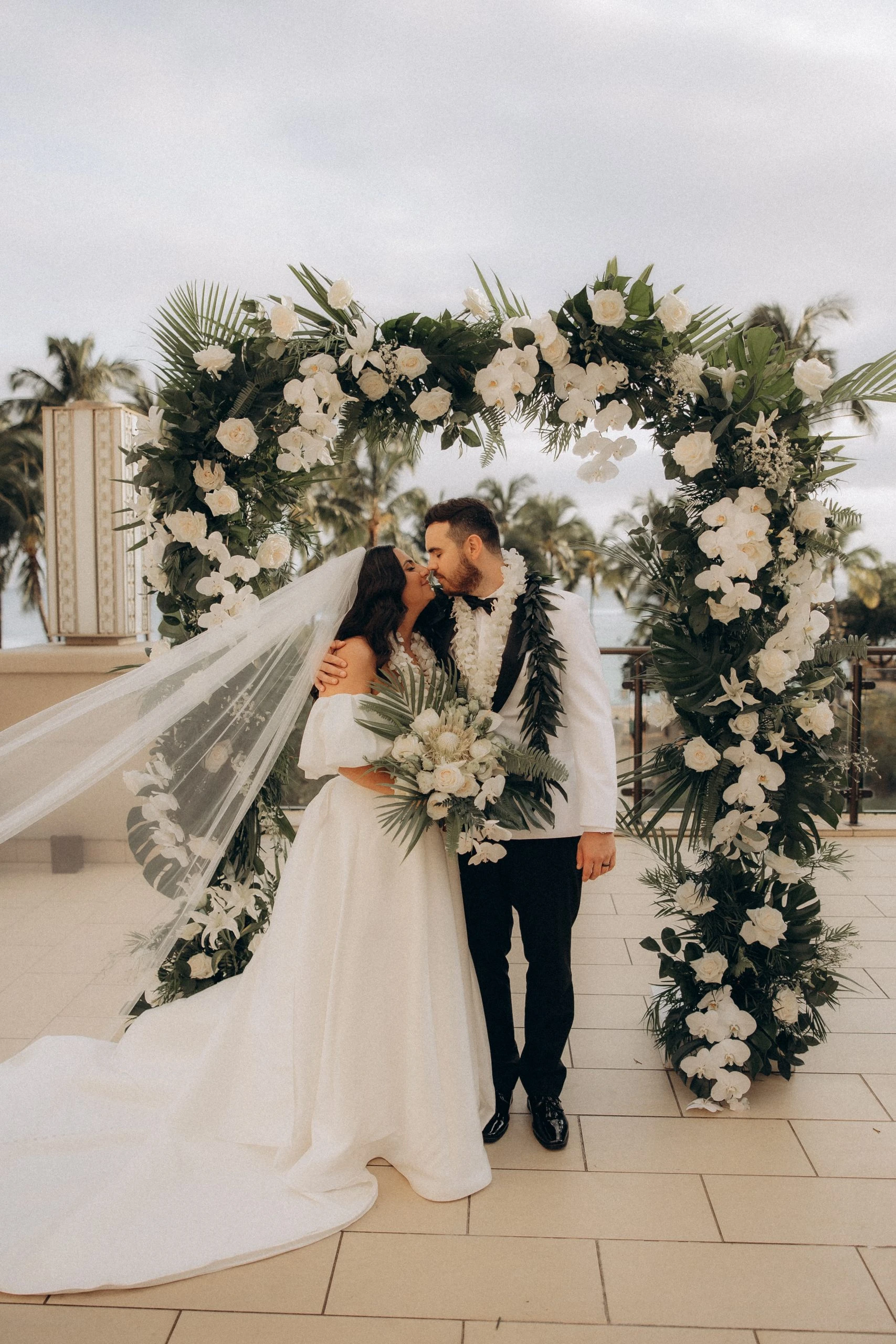 true bride hana kissing husband under hawaiian flower arch - 7601 by Stella York