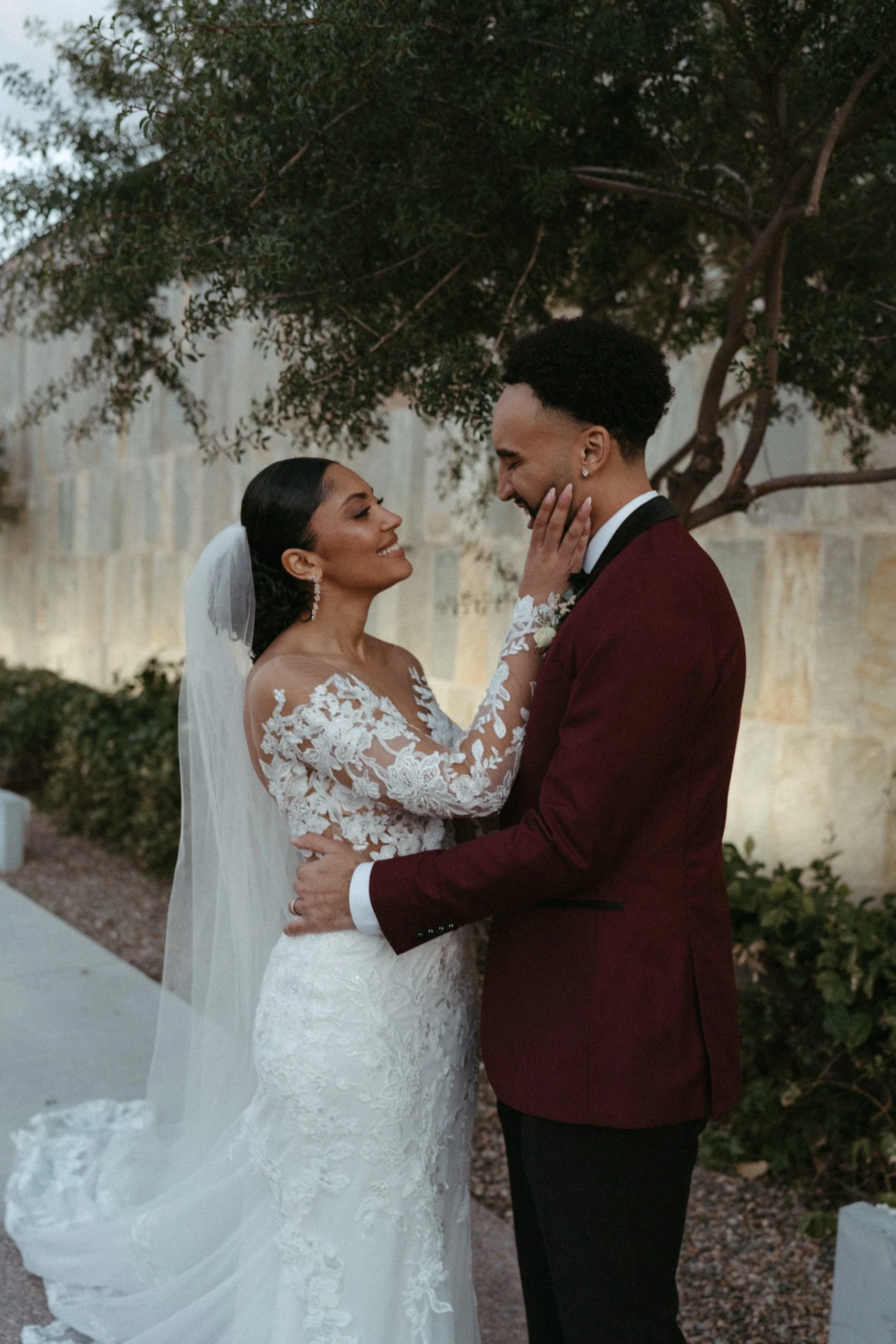 Bride and groom with their arms around eachother looking into eachothers eyes.