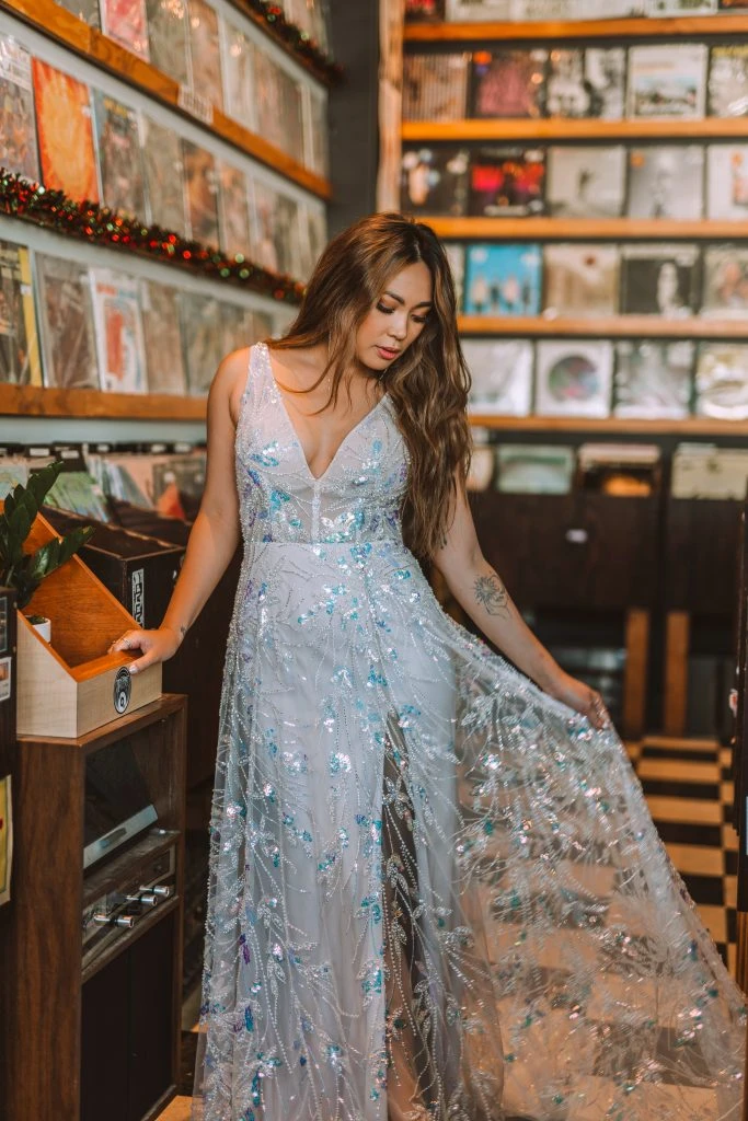 Bride wearing a colorful floral wedding dress in a record shop.