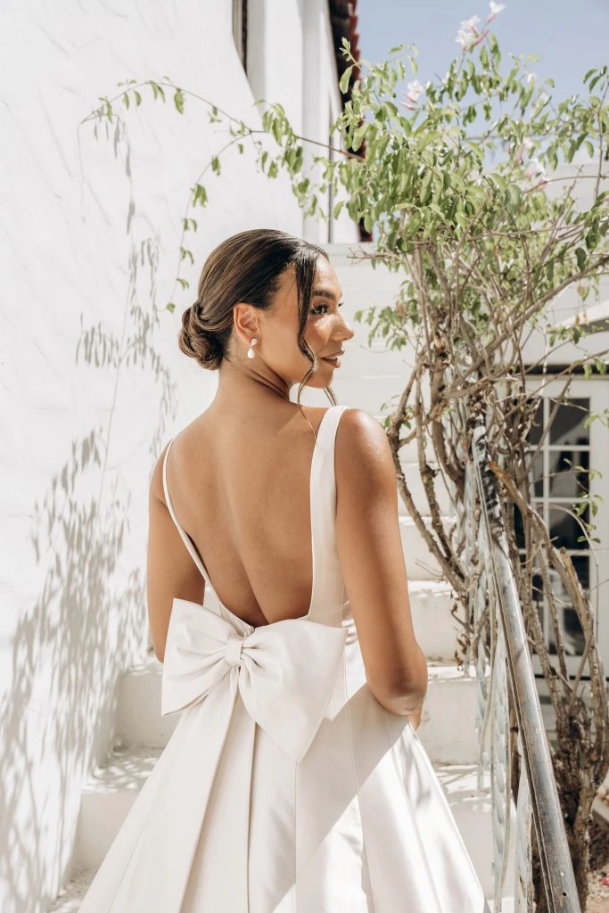 Bride wearing a ballgown wedding dress with a large bow on the back