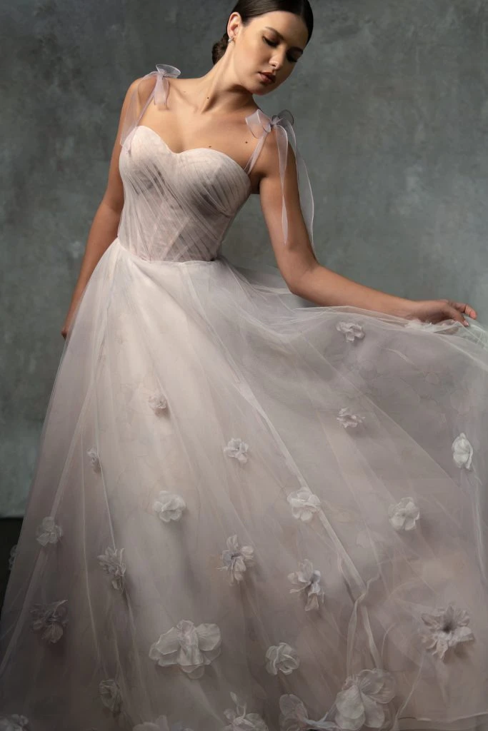 Bride wearing a blush colored wedding dress with 3D florals.