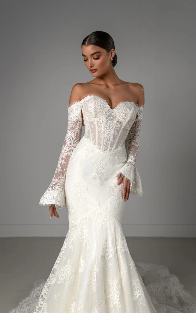 Bride wearing lace fit-and-flare wedding dress with long sleeves, sweetheart neckline and matte floral lace