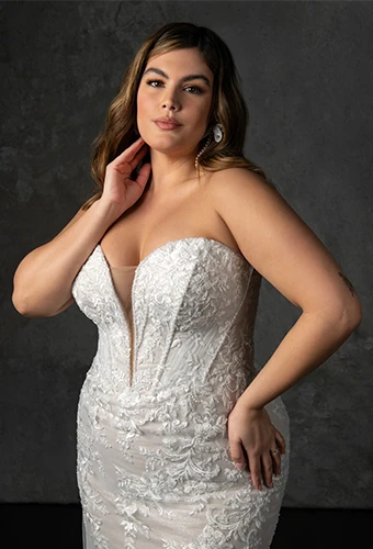 Bride wearing strapless plus size wedding dress with lace appliques and beaded corset