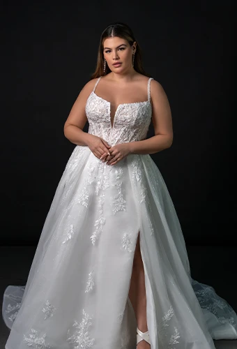Bride wearing plus size lace wedding gown with beaded accents and high leg slit