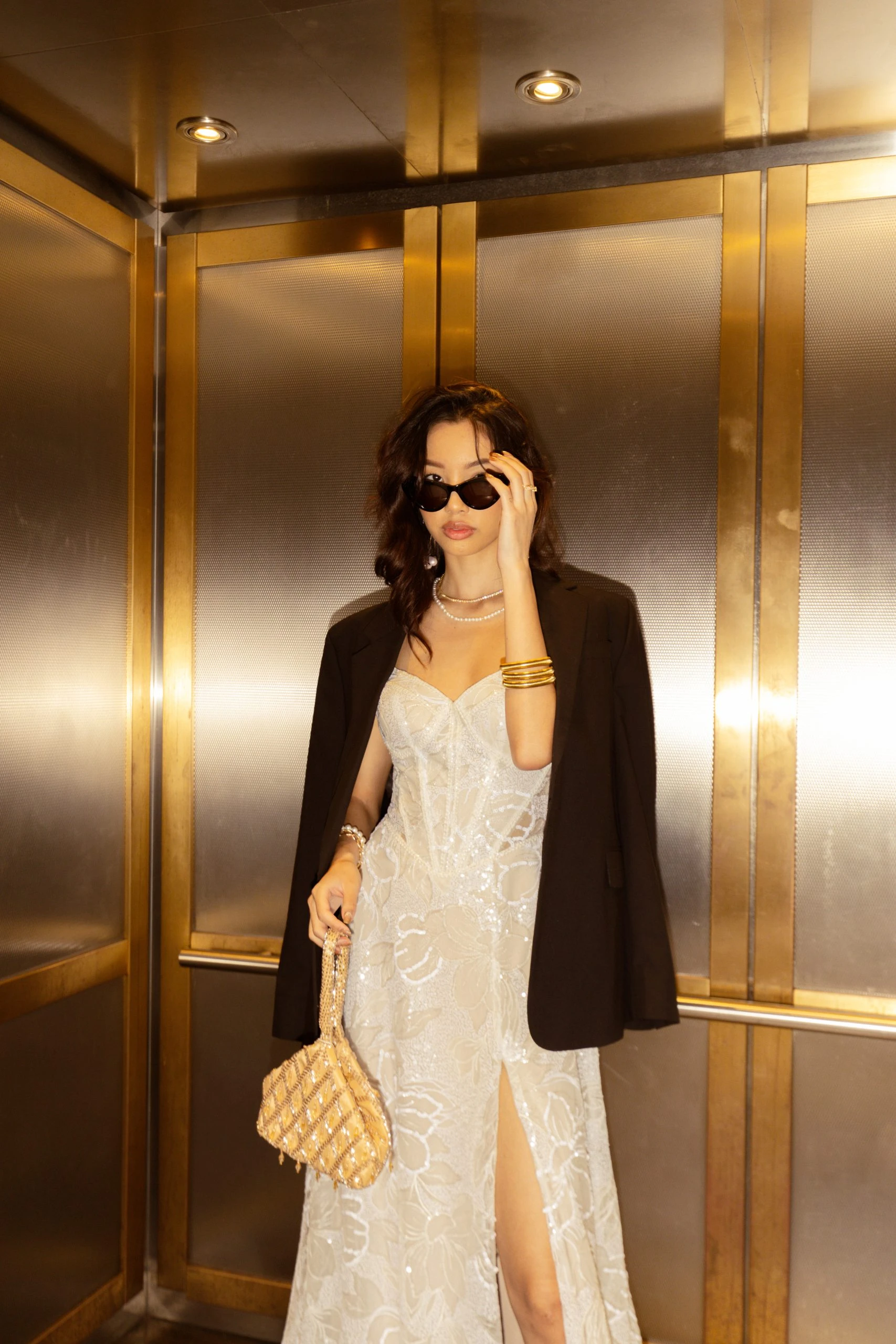 brunette bride in elevator wearing black blazer and sunglasses. All Who Wander style Hattie