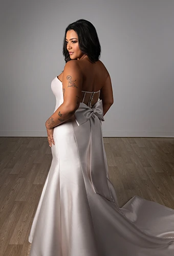 Bride wearing plus size strapless fit-and-flare wedding dress with bow detail