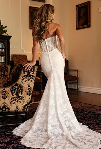 Bride wearing strapless mermaid wedding dress with all over lace and detachable sleeves