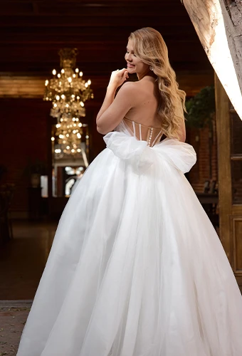 Bride wearing strapless ballgown wedding dress with bow back detail