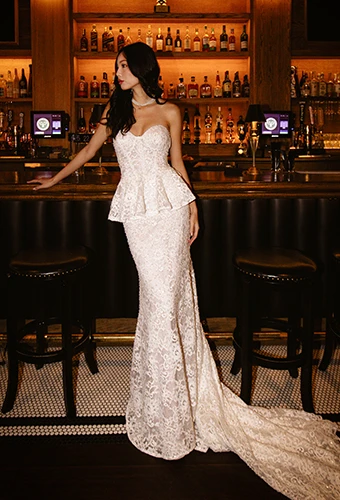 Bride wearing lace strapless mermaid wedding dress with detachable peplum waist