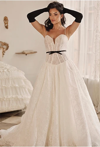 Bride wearing a lace wedding dress with sweetheart neckline and bow belt