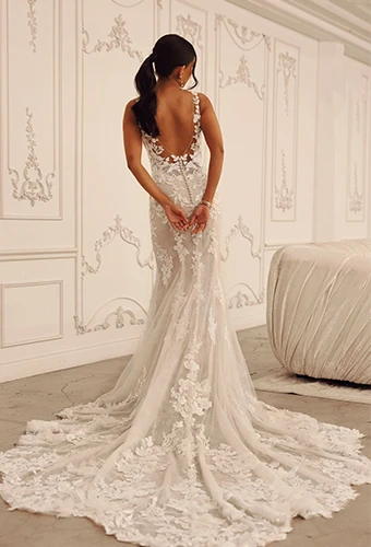 Bride wearing lace wedding dress with ultra low back detail and shoulder straps