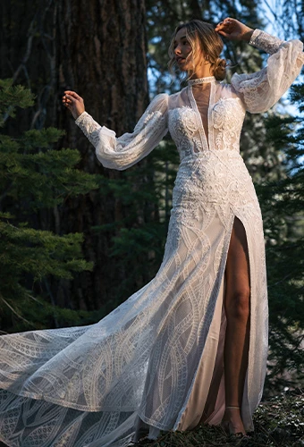 Bride wearing lace long sleeve wedding dress with plunging neckline and high leg slit