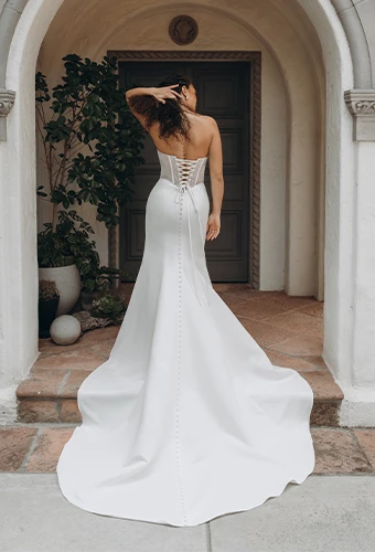 Bride wearing strapless column wedding dress with tie-up back