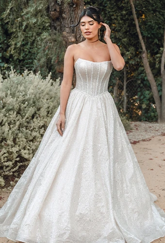Bride wearing sparkling strapless ballgown wedding dress with Basque waist