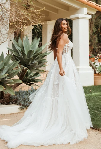 Bride wearing lace ballgown wedding dress with spaghetti straps