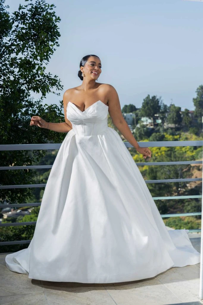 Plus size bride wearing strapless ballgown wedding dress with exposed boning.