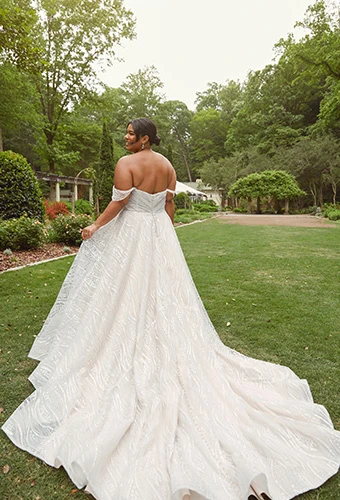 Plus-size bride wearing off-the-shoulder a-line wedding dress.