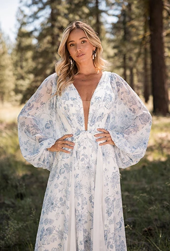bride posing with hands on hips wearing white and blue wedding dress