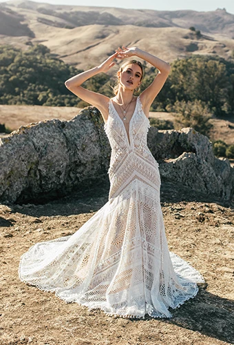 Bride wearing fit-and-flare lace wedding dress posing in the mountains
