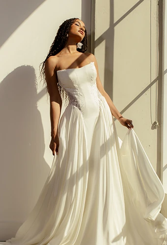 Bride wearing strapless wedding dress with lace details and side cutouts