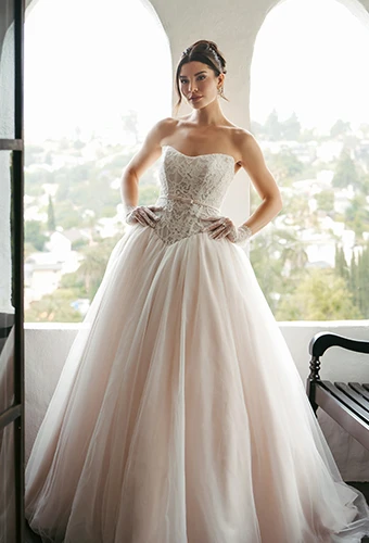 Bride wearing strapless ballgown wedding dress with lace bodice and belt