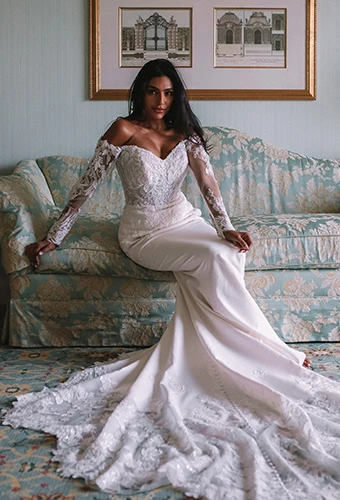 Bride wearing fit-and-flare lace and satin wedding dress with long sleeves
