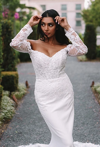 Bride wearing lace and satin wedding dress with long sleeves