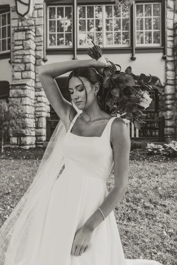 True Bride Genevieve posing in her wedding gown with a bouquet of flowers