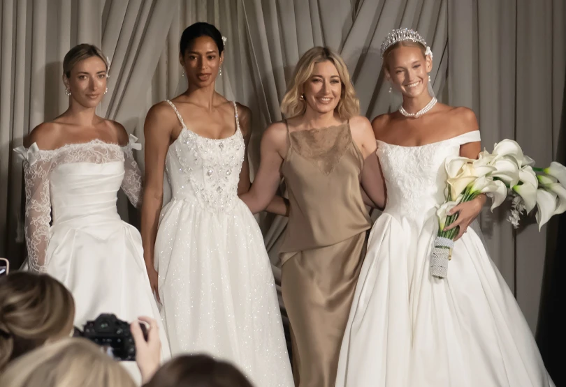 martine harris posing with bridal models after fashion show