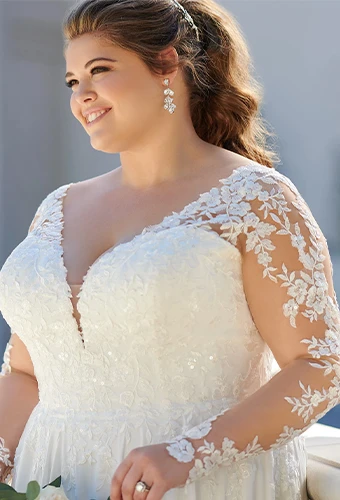 Plus size bride wearing a-line wedding dress with lace illusion sleeves and sweetheart neckline