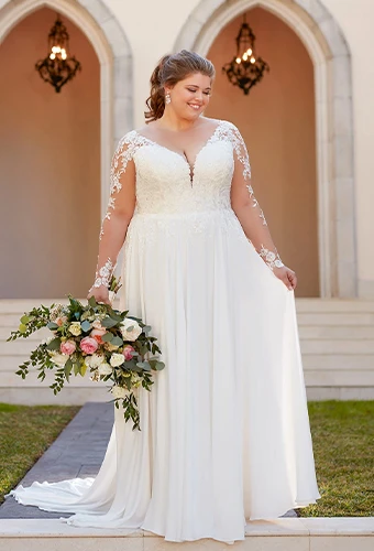 Plus size bride wearing a-line wedding dress with lace illusion sleeves and sweetheart neckline