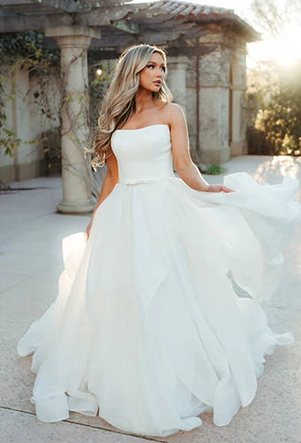 Bride wearing simple strapless wedding dress with bow detail
