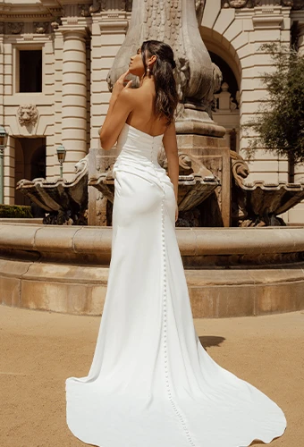 Bride wearing strapless satin wedding gown with fabric-covered buttons