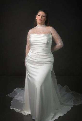 Bride wearing strapless satin fit-and-flare wedding dress with long sleeve lace jacket