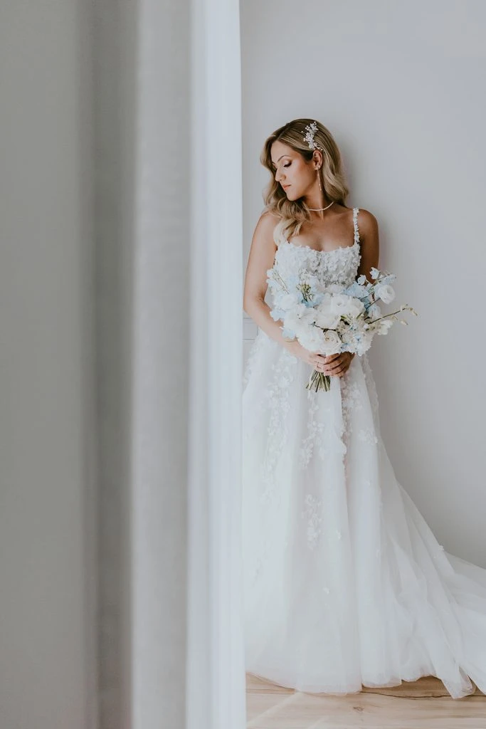 True bride Claudia posing in her wedding gown with a bouquet