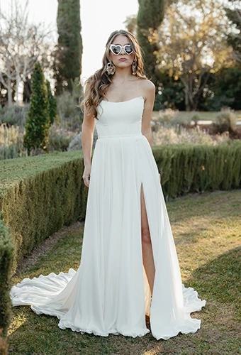 Bride wearing simple strapless wedding dress with high leg slit