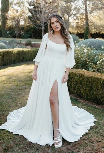 Bride wearing simple wedding dress with blouson sleeves and high leg slit