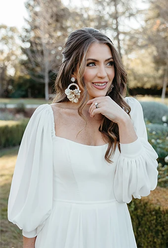 Bride wearing simple wedding gown with scoop neckline line and long blouson sleeves