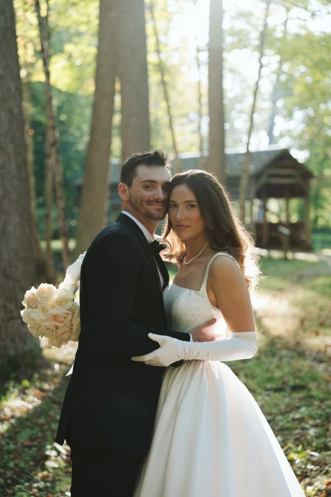 True bride Maya posing with her husband in the woods