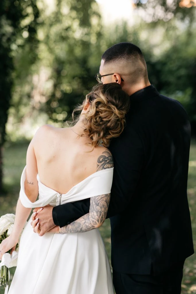 True bride Katharina holding hands and posing with her husband