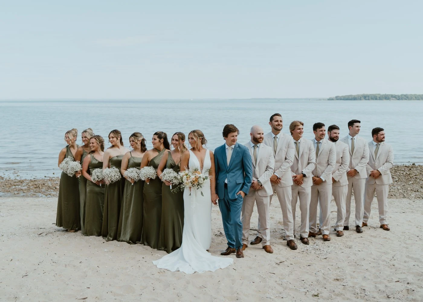 True bride Kelsey posing with her bridal party on lakefront