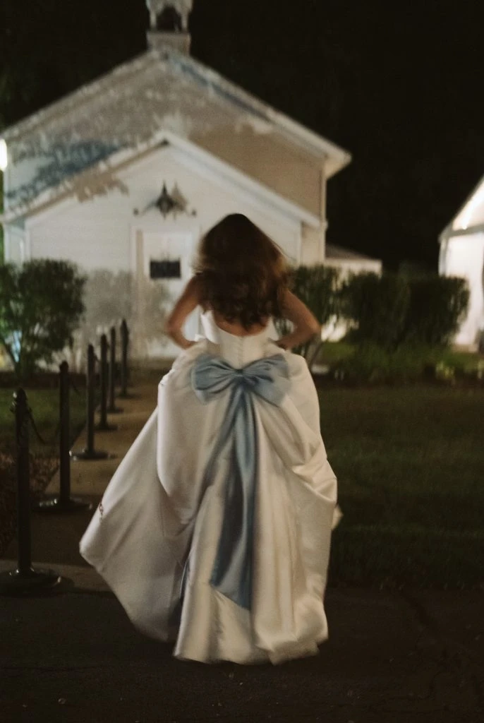 True bride Maya running in her wedding gown showing off the bow back detail