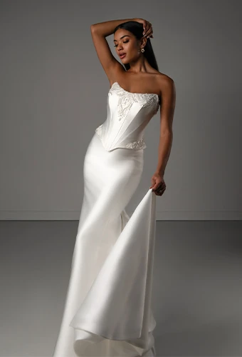 Bride wearing strapless fit-and-flare wedding dress with scoop neckline and beaded detail