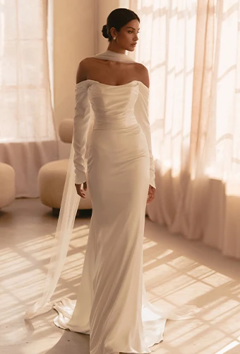 Bride wearing satin long sleeve wedding dress with scoop neckline
