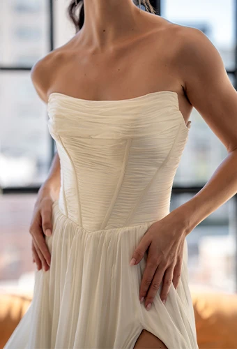Bride wearing simple strapless wedding dress with scoop neckline and high leg slit