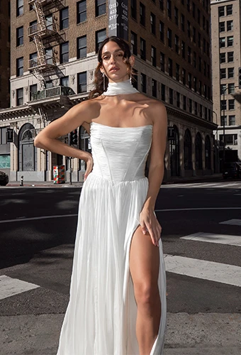 Bride wearing simple strapless wedding dress with scoop neckline and high leg slit