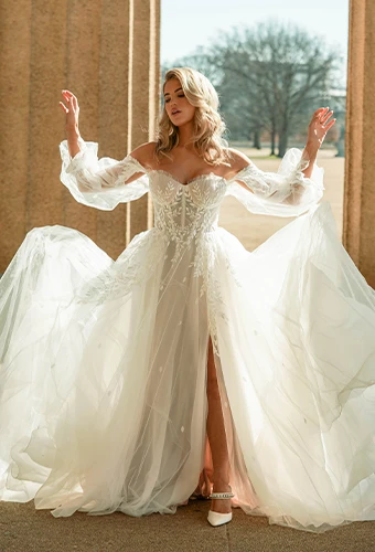Bride wearing strapless wedding dress with detachable blouson sleeves, sweetheart neckline and lace bodice