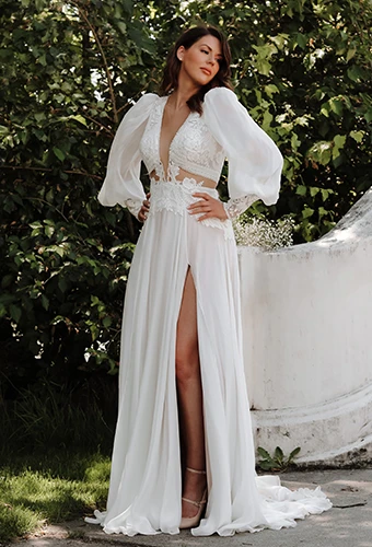 Bride wearing long sleeve wedding dress with plunging v-neckline and high leg slit